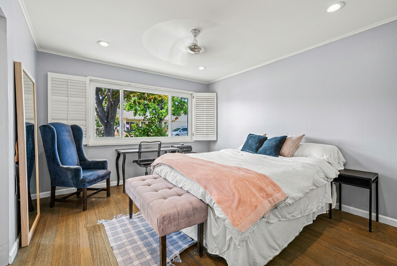 Master bedroom with blue velvet chair and peach throw